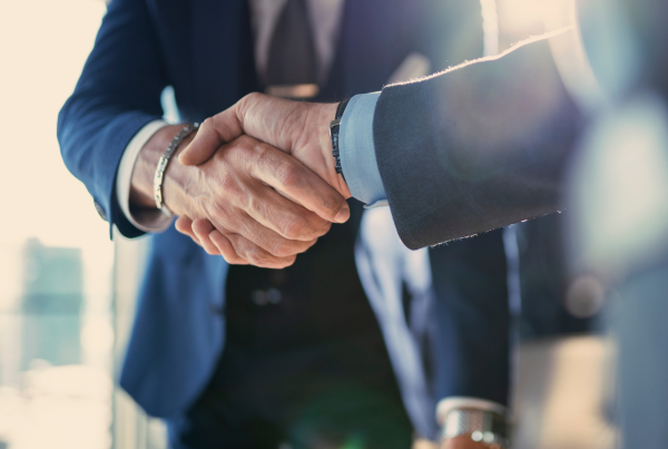 Two men in suits shaking hands.